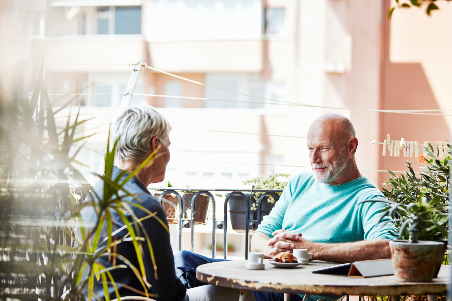 Senior Man Having Breakfast With Woman On Balcony